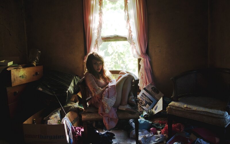 Woman in Cluttered Room — Brown