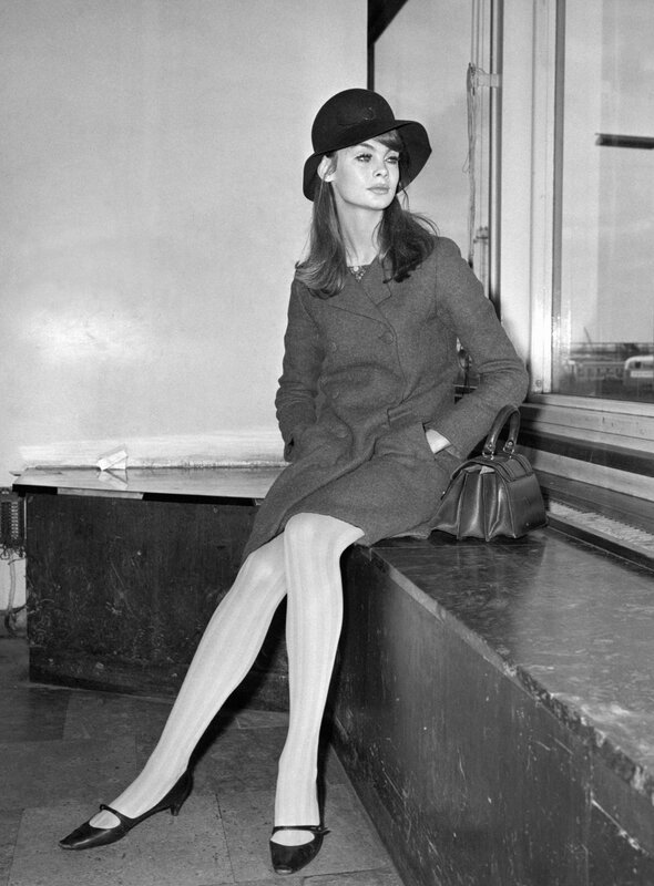 Woman in coat and hat sitting