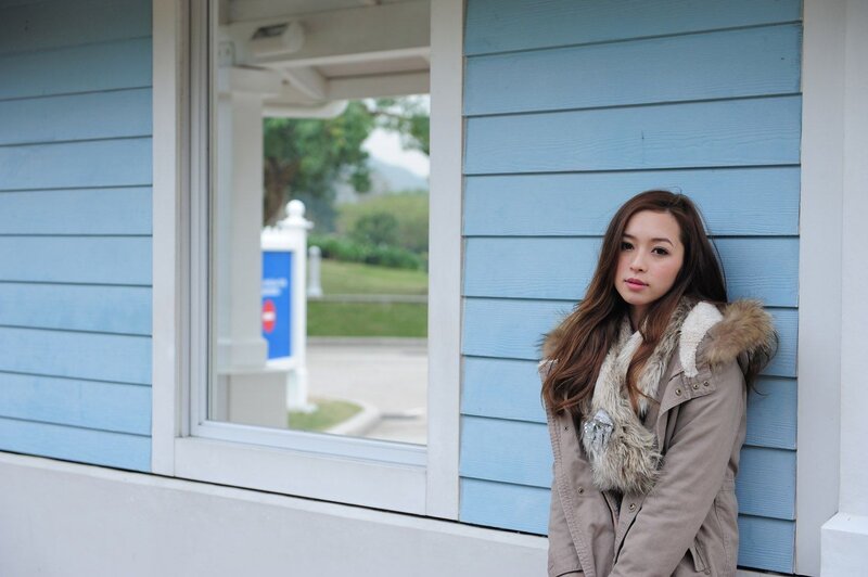 woman in coat by blue wall