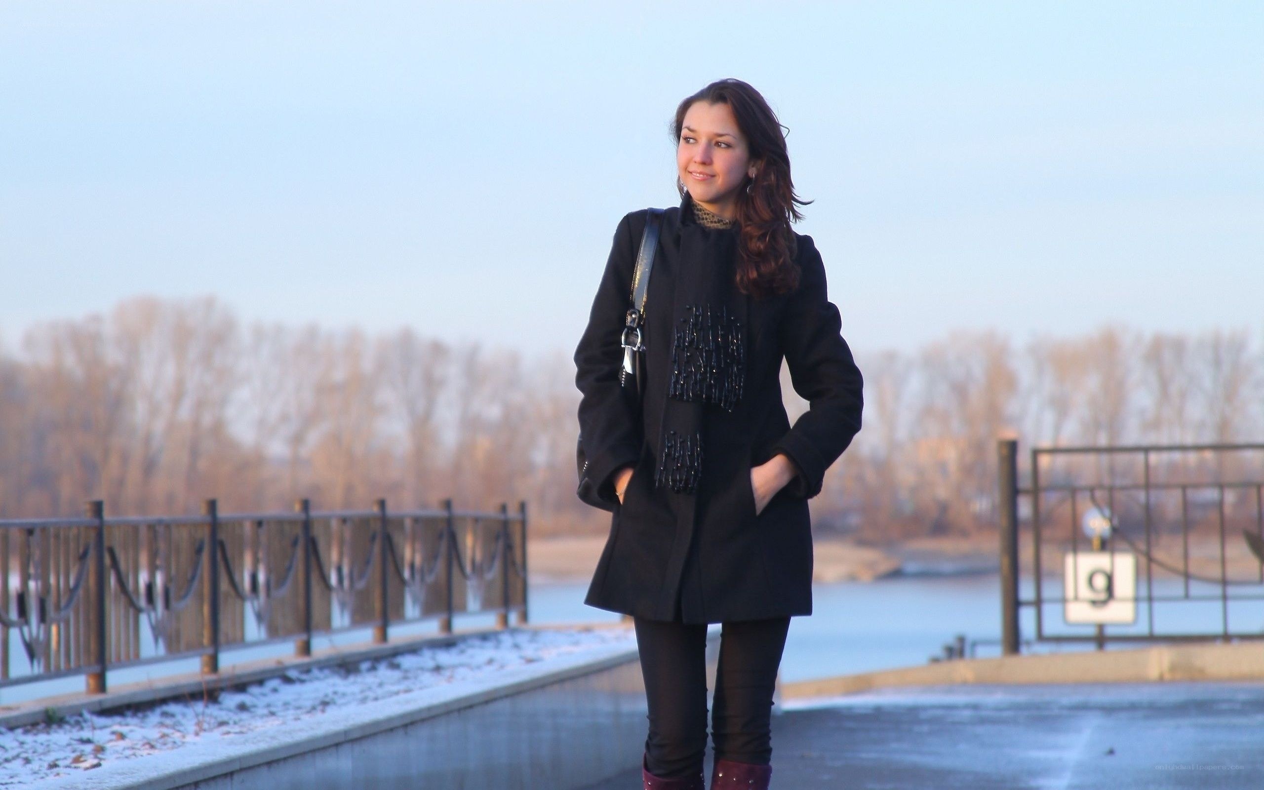 Woman in coat by river