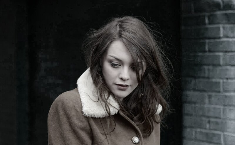 woman in coat looking down