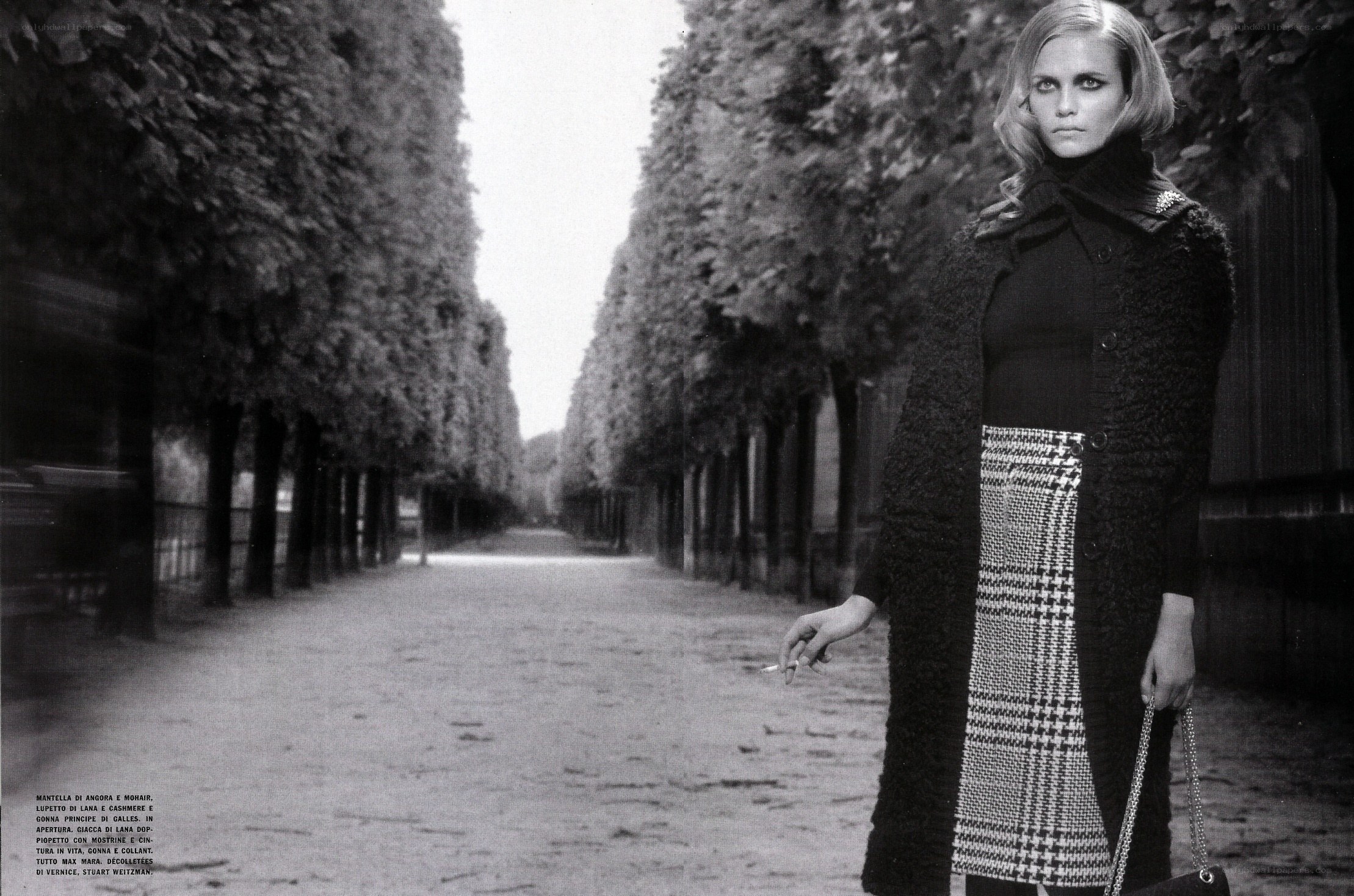 woman in coat on tree-lined path