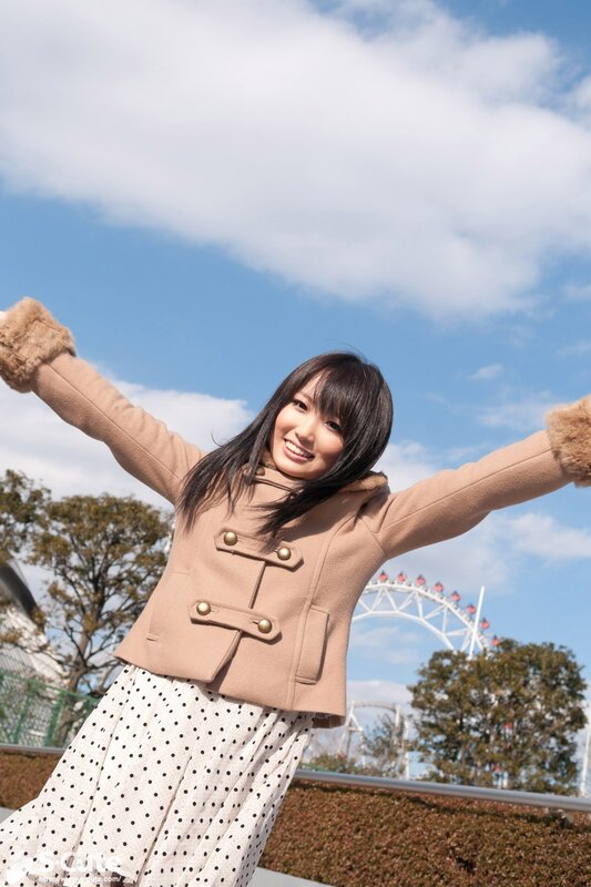 Woman in coat with arms outstretched