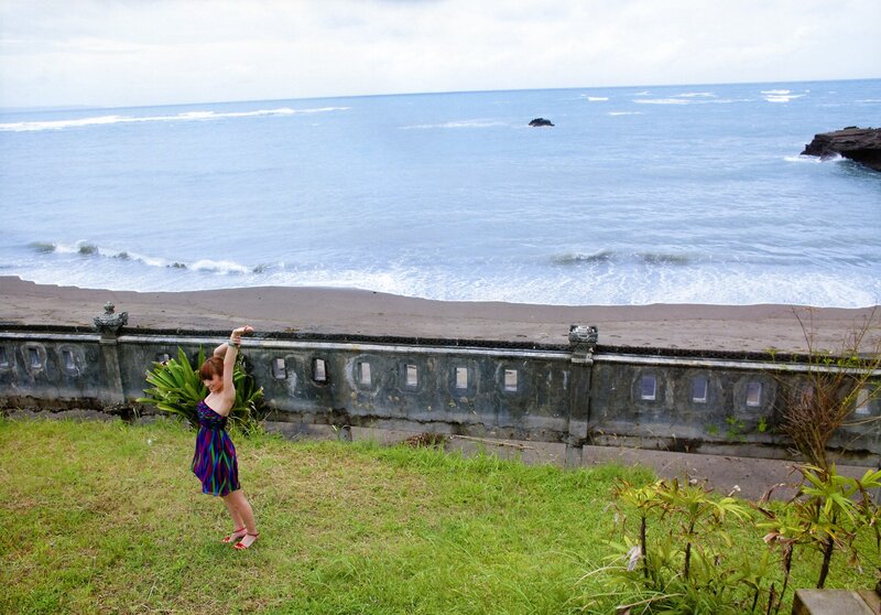 Woman in colorful dress on grassy hill
