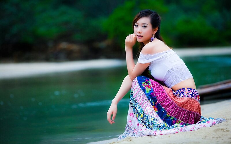 woman in colorful skirt by water