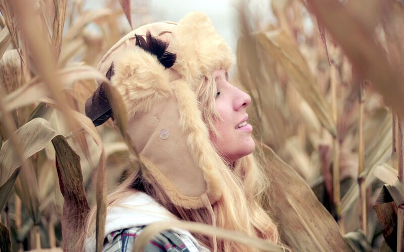 woman in cornfield wearing hat