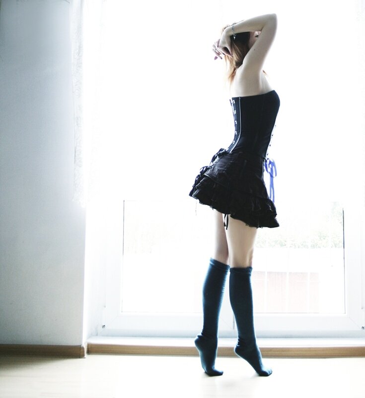 woman in corset by window
