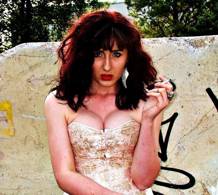 Woman in corset holding cigarette
