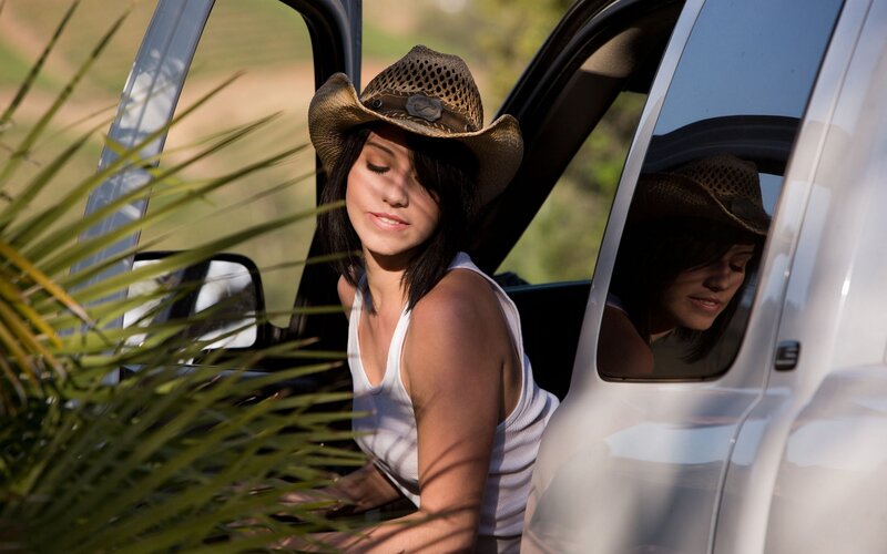 woman in cowboy hat by car