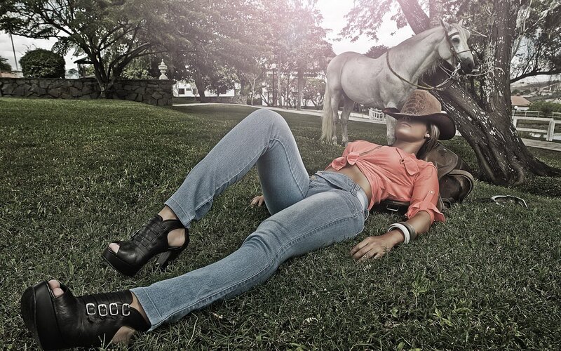 Woman in cowboy hat lying on grass
