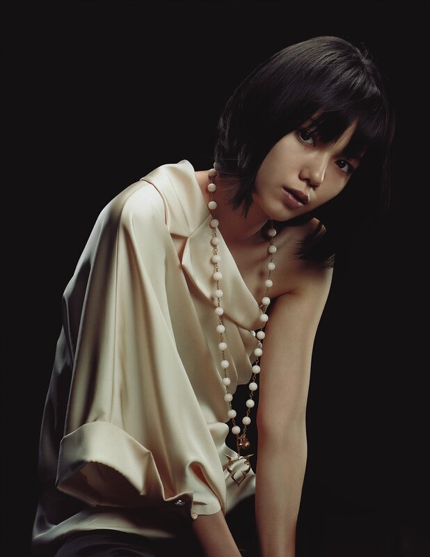 woman in cream blouse with pearl necklace