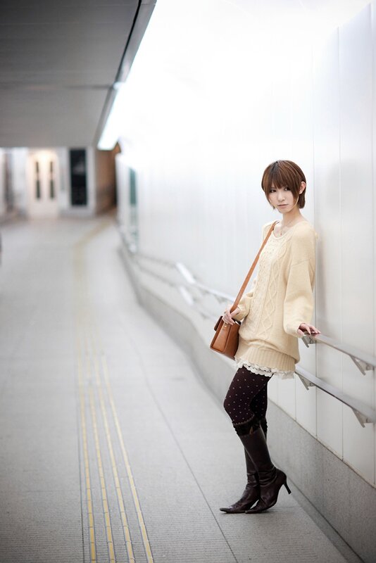 woman in cream sweater standing