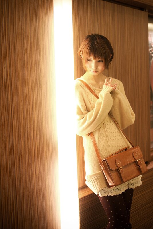 woman in cream sweater with bag