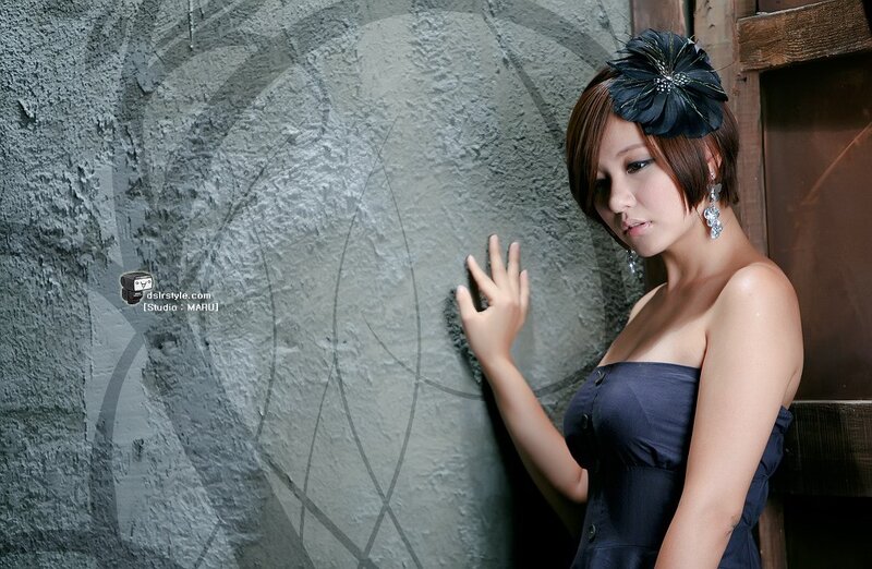 woman in dark dress with flower