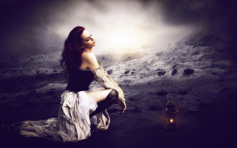 woman in dark landscape with lantern