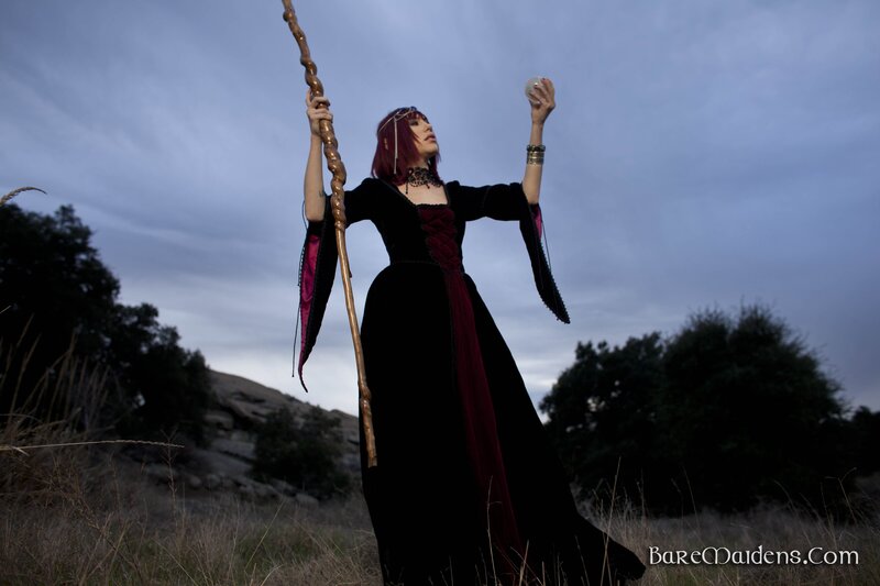 woman in dark robe with staff