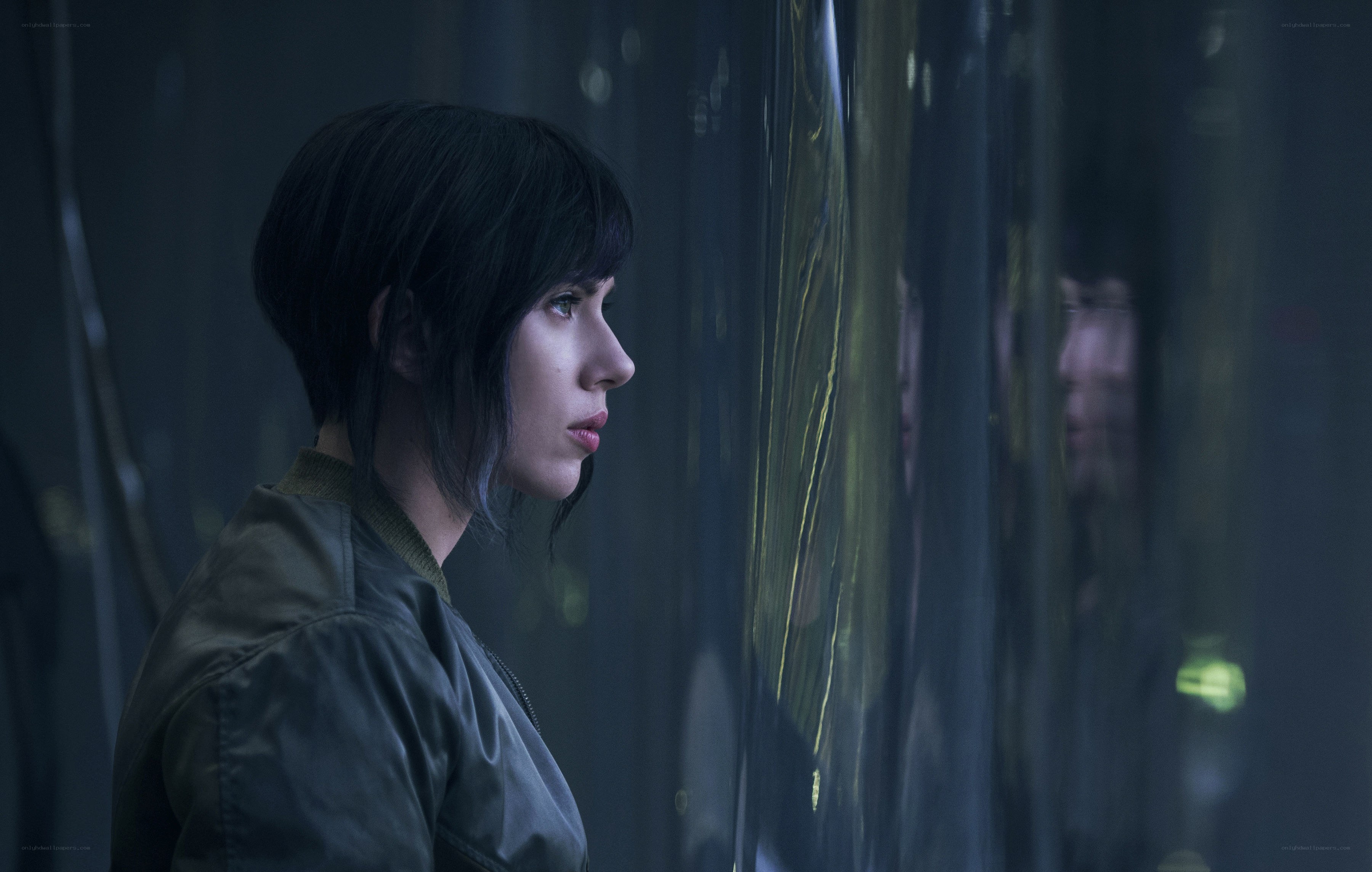 woman in dark room looking at reflection