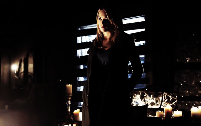 woman in dark room with candles