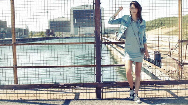 Woman in denim jacket by water