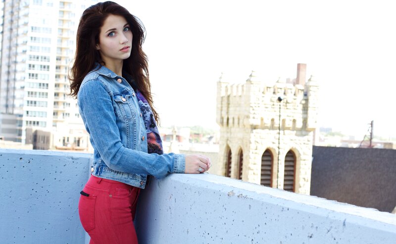 woman in denim jacket on rooftop