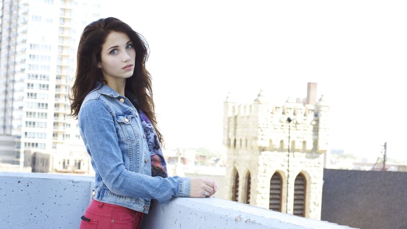 woman in denim jacket on rooftop