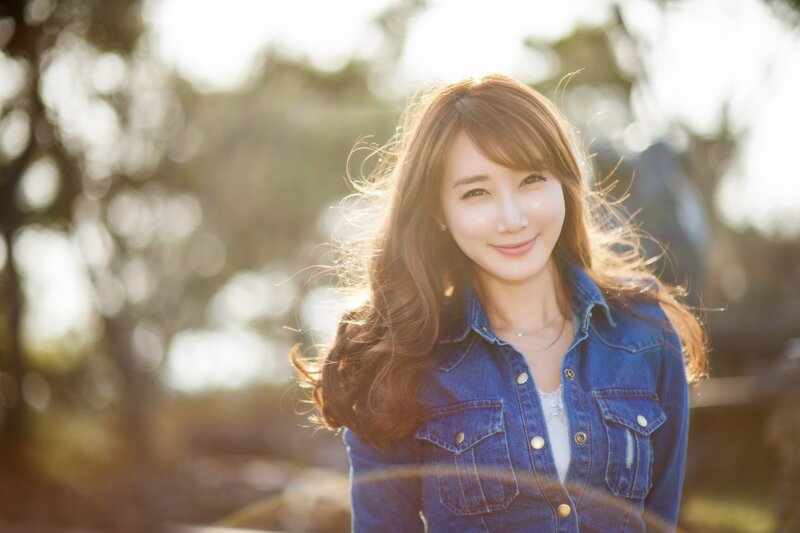 woman in denim jacket smiling