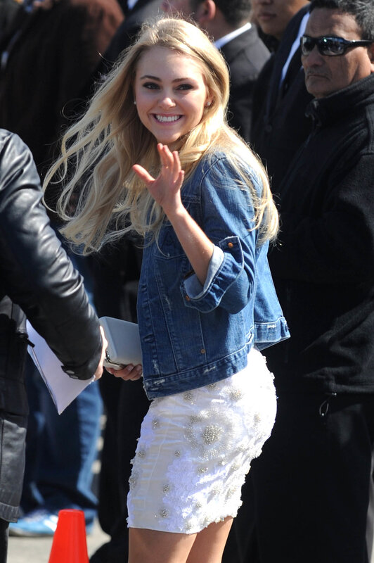 woman in denim jacket waving