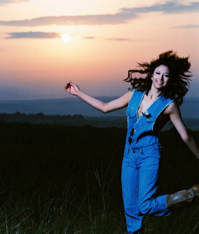 Woman in denim jumpsuit at sunset