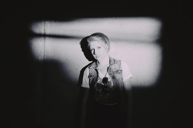 woman in denim vest under spotlight
