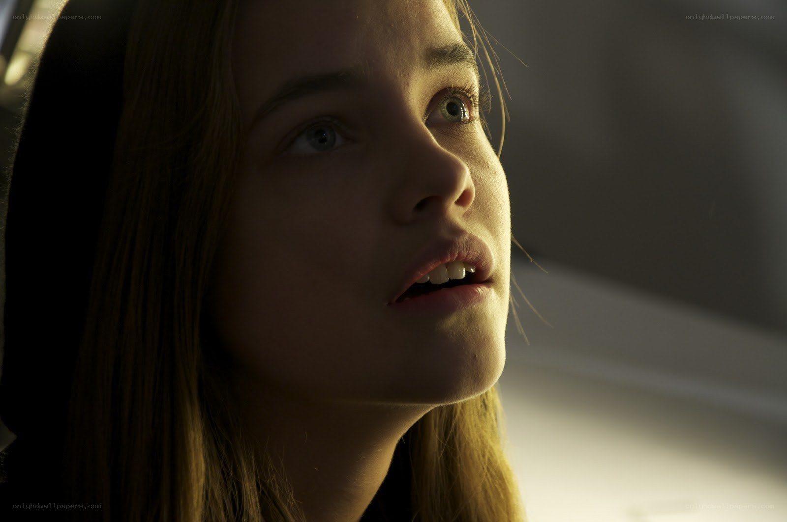woman in dim light looking up