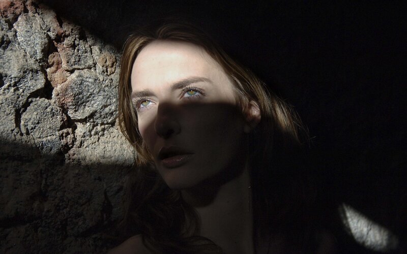 woman in dimly lit stone room