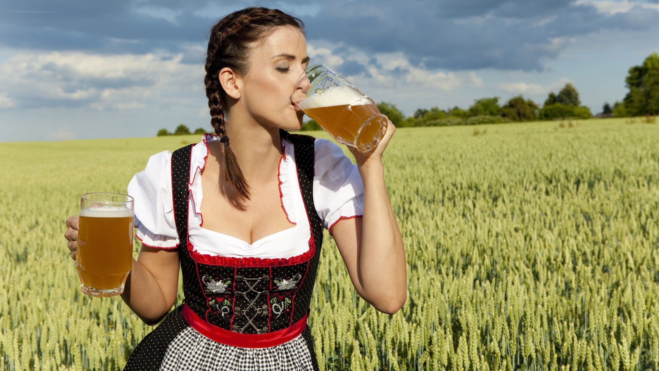 Woman in dirndl drinking beer