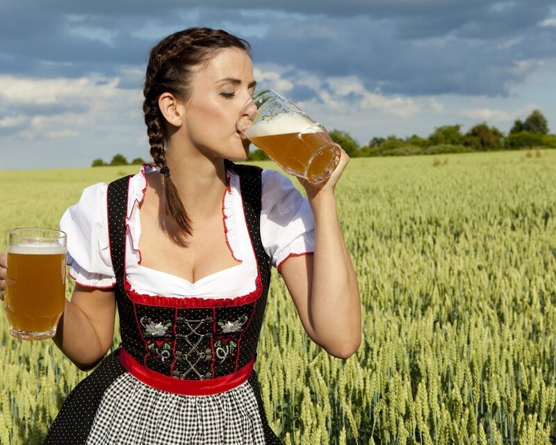 Woman in dirndl drinking beer