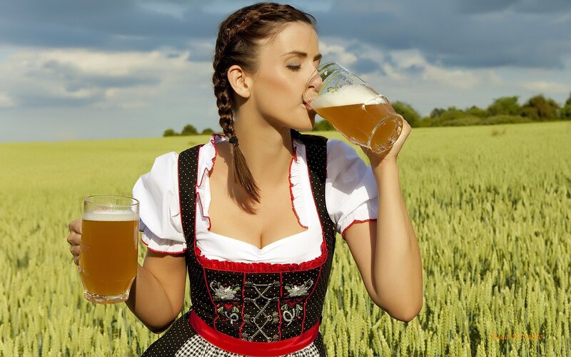 Woman in dirndl drinking beer