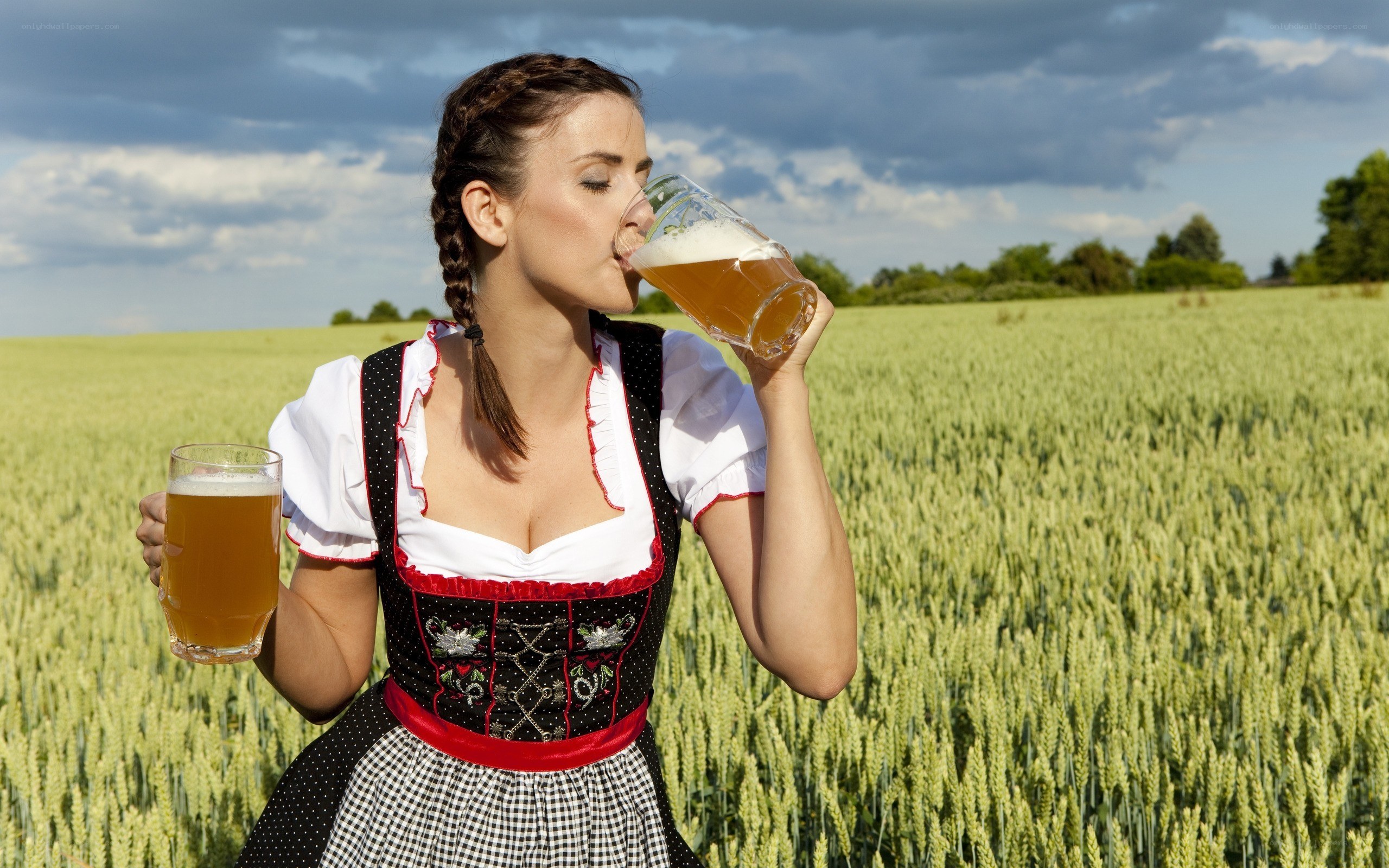 Woman in dirndl drinking beer