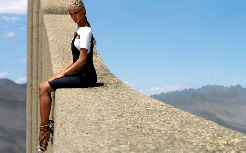 woman in dress on stone ledge