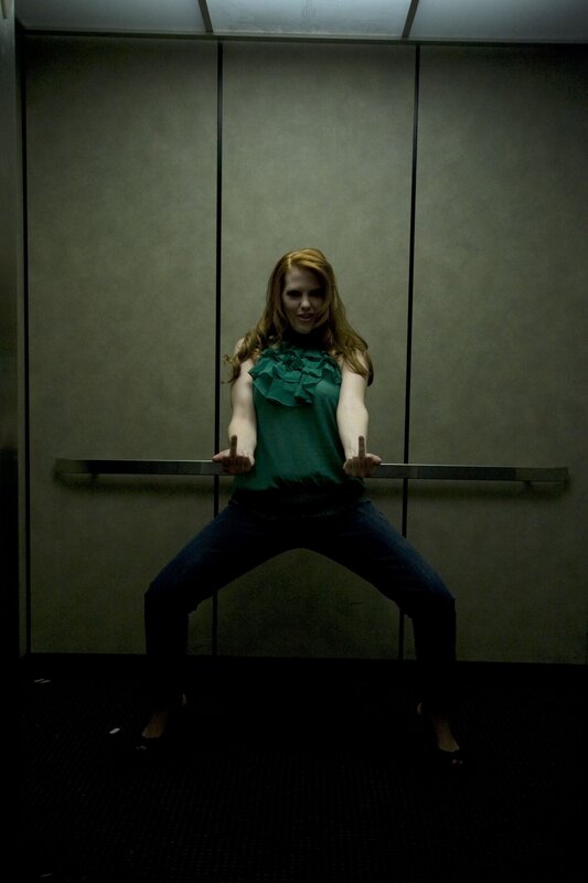 Woman in elevator with hand gesture