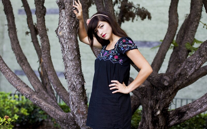 woman in embroidered dress by tree
