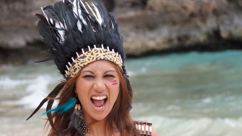 woman in feather headdress at beach