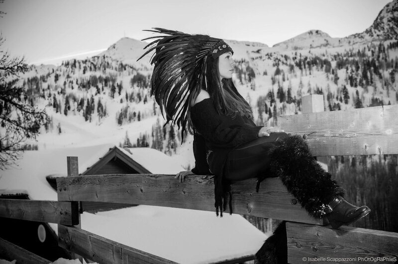 woman in feather headdress on fence