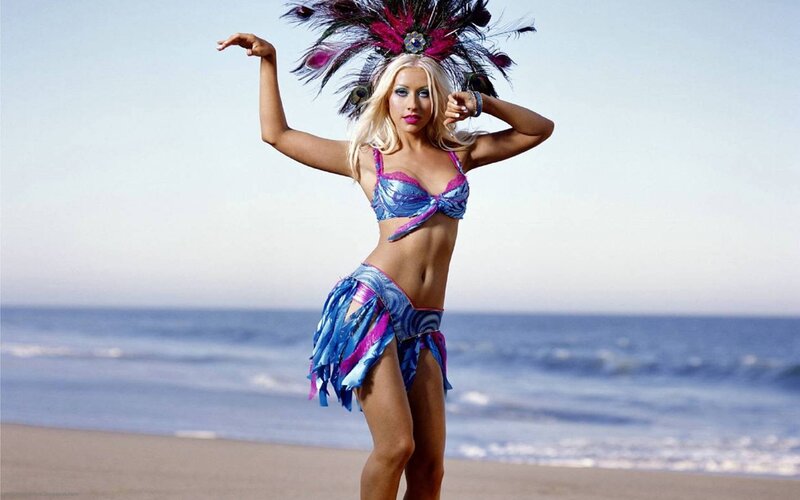 woman in feathered costume on beach