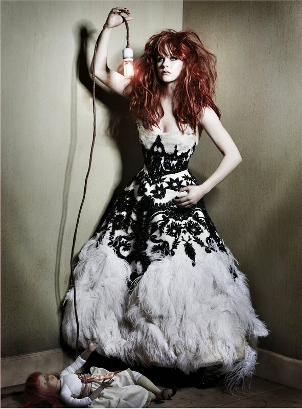 Woman in feathered gown with light bulb