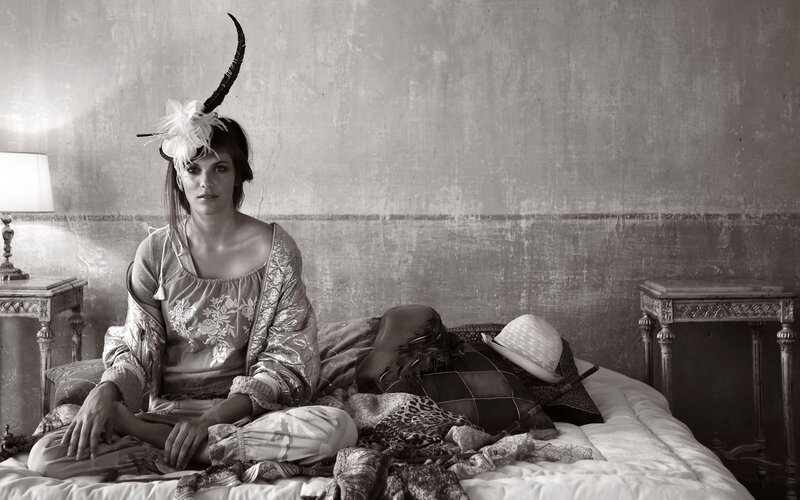 woman in feathered headpiece on bed