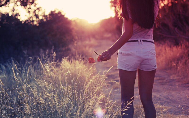 woman in field at sunset
