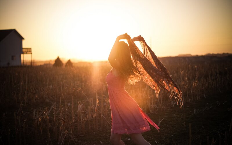 woman in field at sunset