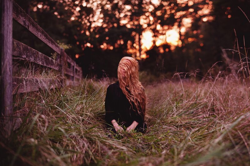 woman in field at sunset