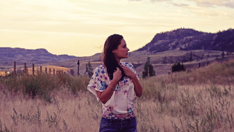 woman in field at sunset