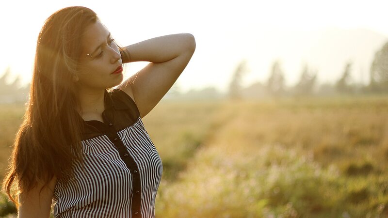 woman in field at sunset