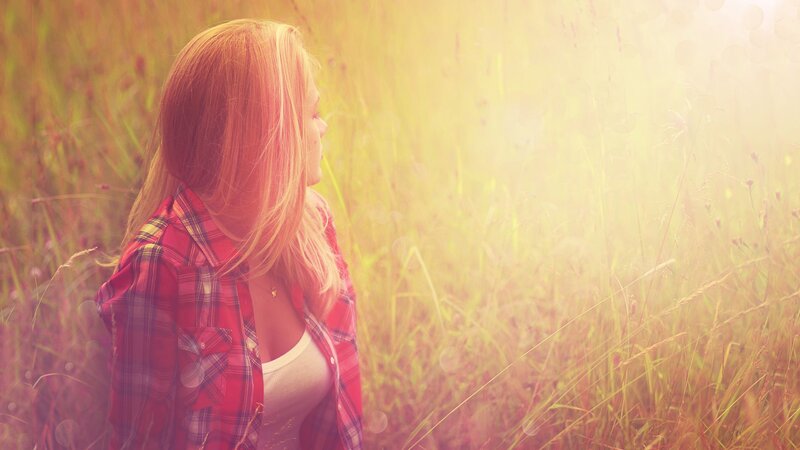 woman in field at sunset