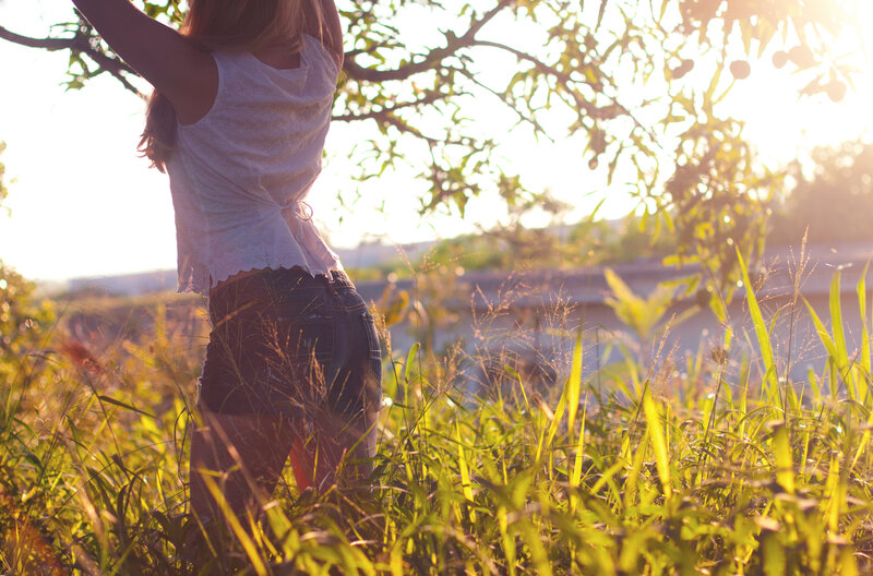 woman in field at sunset